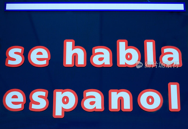 红色和白色的“sehabla espanol”标志，黑暗的橱窗